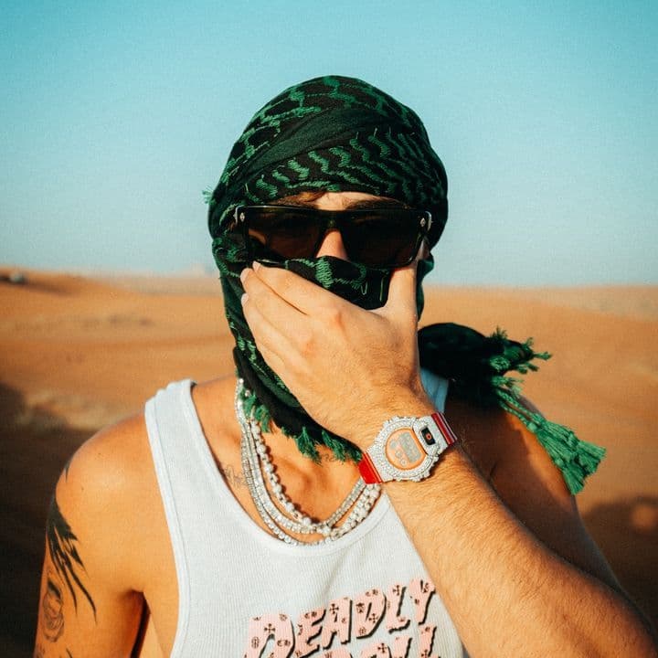 Portrait in desert with green headscarf and sunglasses